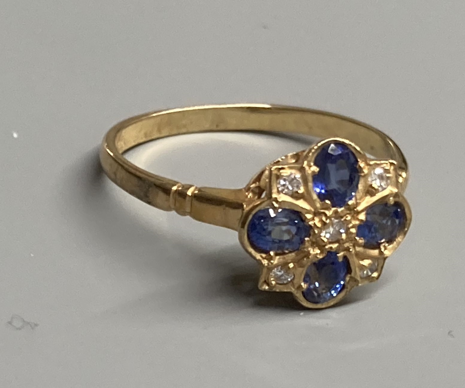 A modern 9ct gold, sapphire and diamond cluster ring, size O, gross 2.2 grams.